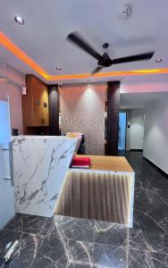 a kitchen with a marble counter and a ceiling fan at Hotel Noble Town in Gandhinagar