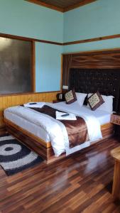a bedroom with a large bed with a wooden headboard at Paradise Village Resort in Shimla