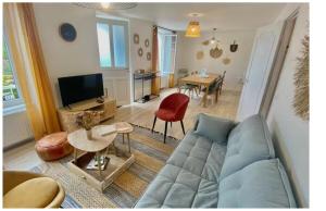 a living room with a blue couch and a table at Jolie maison de familial au cœur de Carantec - TY LAOUEN in Carantec