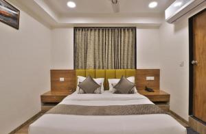 a bedroom with a large bed and a window at Lemon tree premier in Mandsaur