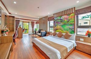 a bedroom with a bed and a large painting on the wall at S79 Khai Ngoc Hotel Dalat in Da Lat