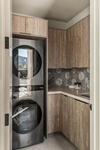 cocina con lavadora y secadora de acero inoxidable en Suncrest by Fieldtrip JT Modern w Pool and Views, en Joshua Tree