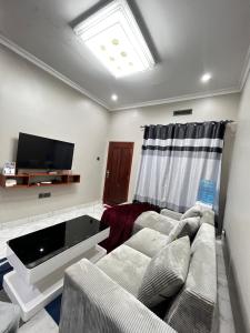 a living room with a couch and a flat screen tv at Hadraj Clocktower Apartment1 in Arusha