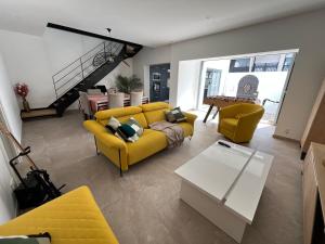 a living room with a yellow couch and chairs at Maison rénovée avec patio plage à pied in Saint-Jean-de-Luz