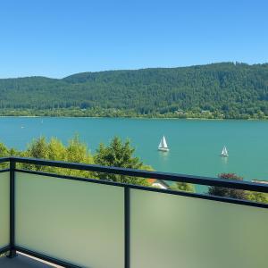 a view of a lake with two boats in the water at Lake Lodge Ossiacher See in Annenheim