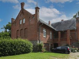 an old brick building with a car parked in front at Troja Ferienwohnung in Kalkhorst