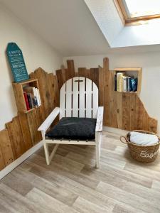 a white chair in a room with a book shelf at Casa Cocon -Charmant T3-plages, centre ville- 4 personnes in Pornic