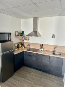 a kitchen with a sink and a refrigerator at Casa Cocon -Charmant T3-plages, centre ville- 4 personnes in Pornic
