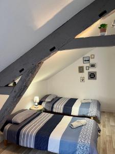 two beds in a room with a attic at Casa Cocon -Charmant T3-plages, centre ville- 4 personnes in Pornic