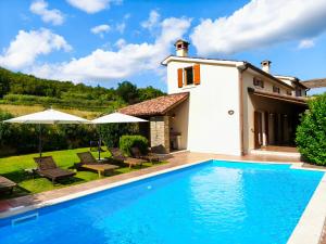 a villa with a swimming pool in front of a house at Villa Dol in Buzet