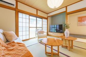 a living room with a couch and a table at 10min Nagoya 18ppl 4BR 50min Centrair 8Beds 2Futon in Nishi-biwashima