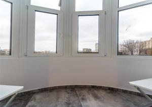 a white room with windows and a fireplace at Urban Retreat Near Metro & Mega Mall in Bucharest