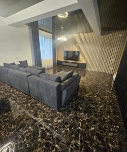 a living room with a couch and a television at IUNIk in Azuga