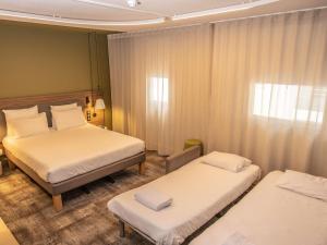 a hotel room with two beds and a window at Novotel Suites Clermont Ferrand Polydome in Clermont-Ferrand