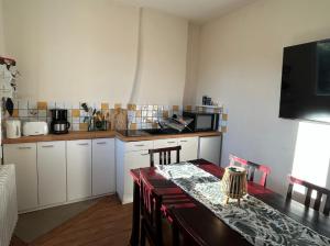 a kitchen with white cabinets and a table with a counter top at Logement Salbris sologne in Salbris