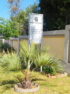 ein Schild für einen Parkplatz mit einer Palme in der Unterkunft Tokelo Guesthouse Emalahleni in Witbank