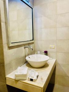 a bathroom with a white bowl sink on a counter at De Tabies Luxury Suites in Rawalpindi
