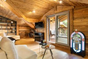 una sala de estar con paredes de madera y una gran ventana. en Black Diamond - Chalet Charlie, en Les Brévières