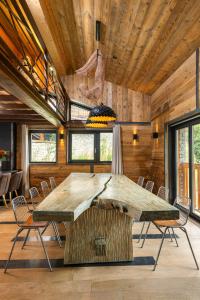 una gran mesa de madera en una habitación con sillas en Black Diamond - Chalet Bansky, en Les Brévières