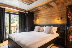 Un dormitorio con una cama grande con una pared de madera. en Black Diamond - Chalet Bansky, en Les Brévières 34 fotos más