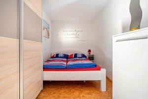 德兰斯克Bungalow 'zur Möwe' Bgl 21的小卧室配有蓝色和红色枕头的床