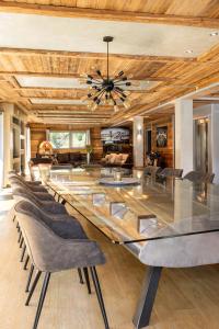 a dining room with a large glass table and chairs at Black Diamond - Chalet Tango in Les Brévières