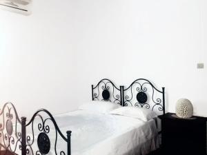 モンテローニ・ディ・レッチェにあるCasa Vacanze Villa Martinoの白いベッド(黒枠、白い枕付)