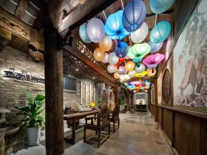 Un pasillo con una mesa y faroles de colores. en 成都鹪鹩人文精品酒店, en Chengdú