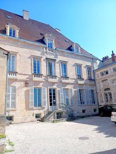 a large stone building with a staircase in front of it at Lemullier de Bressey - Hôtel particulier au coeur de Dijon in Dijon