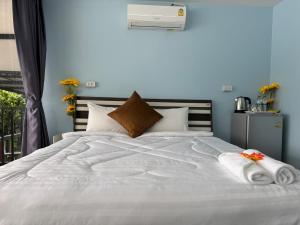 a white bed with towels on top of it at Riverside Hostel Phuket in Phuket