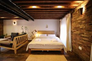 a bedroom with a bed and a chair and a brick wall at Balcony apartment- 50m from Patan Durbar Sq in Pātan