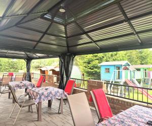 a patio with tables and chairs under a canopy at Dworek Nad Stawem & Łaźnia Piwna in Ostrów Mazowiecka