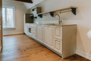 a kitchen with white cabinets and a sink at 2 room apartment in Sikana Manor 