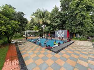 grupa ludzi w basenie w parku w obiekcie Karjat In Resort By Karjat Stays w mieście Karjat