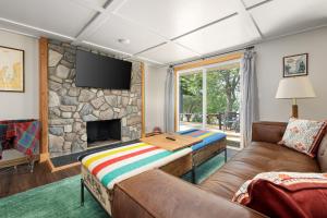 a living room with a couch and a stone fireplace at Dyer Lake Gallery Retreat - Lakefront - Deck - Fire Pit in Grawn