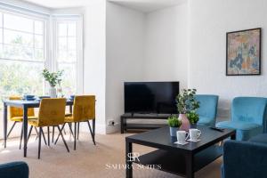 a living room with a table and chairs and a television at Modern 4-Bedroom Home in Newport - Driveway Parking - Contractors Stay in Newport