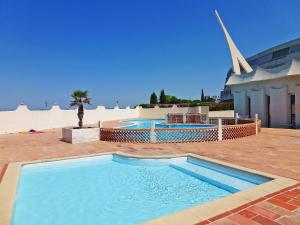 a large swimming pool with a church in the background at Apartment Le Chabian.10 in Le Grau-du-Roi