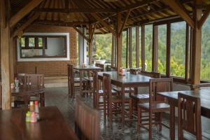 a restaurant with wooden tables and chairs and a television at Puri Alam Bali in Munduk