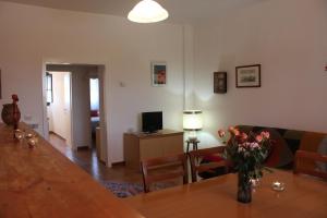 a living room with a table with a vase of flowers on it at Casale La Barca in Albinia