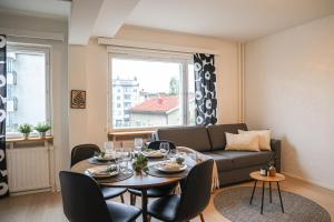 un salon avec une table et un canapé dans l'établissement Aurora Central Suite III By BookLapland, à Rovaniemi