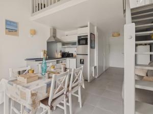 a kitchen and dining room with a table and chairs at Appartement avec piscine commune pour 4 in Guérande