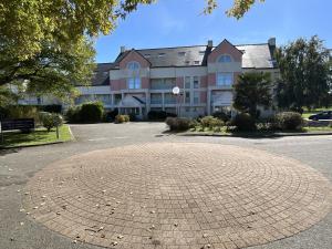 a large building with a brick circle in front of it at Appartement avec piscine commune pour 4 in Guérande