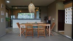 a dining room with a wooden table and chairs at Lemon Hills Kuta in Kuta Lombok