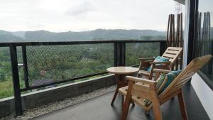 two chairs and a table on a balcony with a view at Lemon Hills Kuta in Kuta Lombok