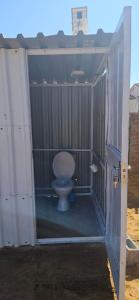 a bathroom with a toilet inside of a stall at The Kimberlite Camping & Caravan Parking, Jwaneng in Jwaneng