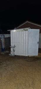 a white shed with a toilet in front of it at The Kimberlite Camping & Caravan Parking, Jwaneng in Jwaneng