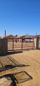a fence in the middle of a dirt field at The Kimberlite Camping & Caravan Parking, Jwaneng in Jwaneng