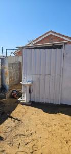 a white shed with a table in front of it at The Kimberlite Camping & Caravan Parking, Jwaneng in Jwaneng
