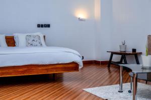 a bedroom with a bed and a wooden floor at Maggiez Leisure Home Dodoma in Dodoma +24 photos