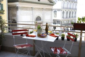 - une table et des chaises sur un balcon avec une bouteille de vin dans l'établissement Napoli Bonita b&b, à Naples